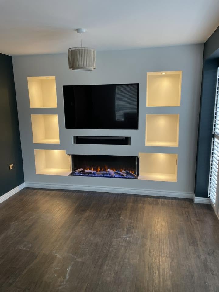Living room decorated by PJH Decor with a dark painted feature wall and built-in shelving